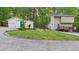 View of a light yellow home with a matching detached garage and a gravel parking area at 196 Tara Ln, Timberlake, NC 27583
