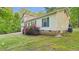 View of the side and back of the house with lush green grass and shrubbery at 196 Tara Ln, Timberlake, NC 27583
