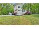 View of the house with light yellow siding, stone accents, green shutters, and a lush lawn at 196 Tara Ln, Timberlake, NC 27583