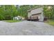 Back of house with light yellow siding, stone accents, and green shutters, with an outbuilding to the left at 196 Tara Ln, Timberlake, NC 27583
