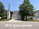 Traditional two-story home featuring a two-car garage and a well-manicured lawn with mature trees at 2018 Groundwater Pl, Raleigh, NC 27610