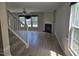 Bright living room with hardwood floors, a ceiling fan, a fireplace, and staircase at 2018 Groundwater Pl, Raleigh, NC 27610
