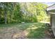 A well-manicured backyard featuring a level grassy area with wooded surroundings at 2027 Jefferson Dr, Hillsborough, NC 27278