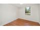 A serene bedroom with hardwood floors and a window with backyard views at 2027 Jefferson Dr, Hillsborough, NC 27278