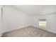 A quiet bedroom with neutral carpeting, built in closet, and view of the yard at 2027 Jefferson Dr, Hillsborough, NC 27278
