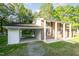 Brick home featuring an attached carport, front porch with stately columns and manicured lawn at 2027 Jefferson Dr, Hillsborough, NC 27278