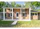 A brick home featuring a covered front porch with white columns and black shutters at 2027 Jefferson Dr, Hillsborough, NC 27278