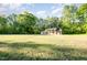 Traditional brick home with a large front yard and mature trees under a sunny sky at 2027 Jefferson Dr, Hillsborough, NC 27278