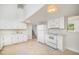 Clean kitchen with all-white appliances, cabinets, countertops and view of the staircase at 2027 Jefferson Dr, Hillsborough, NC 27278