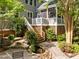 Landscaped backyard featuring stone steps, a pond, and screened-in porch at 204 Rossburn Way, Chapel Hill, NC 27516