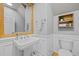 Charming bathroom featuring a pedestal sink, decorative mirror, and wainscoting at 204 Rossburn Way, Chapel Hill, NC 27516