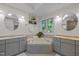 Bright bathroom with bathtub, double vanity, and a window overlooking backyard at 204 Rossburn Way, Chapel Hill, NC 27516