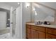 Bathroom featuring a vanity with storage, a shower with tiled surround, and modern lighting at 204 Rossburn Way, Chapel Hill, NC 27516