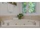 A close up of a white bathtub with chrome fixtures and an outside view at 204 Rossburn Way, Chapel Hill, NC 27516