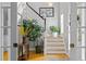 Bright hallway with hardwood floors, a staircase, and decorative plants, creating an inviting transition space at 204 Rossburn Way, Chapel Hill, NC 27516
