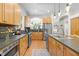 Bright kitchen with a stainless steel refrigerator, an island, and wood cabinets at 204 Rossburn Way, Chapel Hill, NC 27516