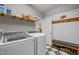 Well-organized laundry room with modern appliances, shelving, and a seating bench at 204 Rossburn Way, Chapel Hill, NC 27516
