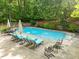 Inviting in-ground pool surrounded by lounge chairs and lush greenery in a private backyard at 204 Rossburn Way, Chapel Hill, NC 27516