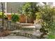 Stone steps lead to a charming entrance, framed by lush greenery and elegant potted plants at 204 Rossburn Way, Chapel Hill, NC 27516