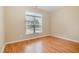 Empty bedroom featuring hardwood floors, neutral walls, and a large window providing natural light at 209 Mccarthy Dr, Clayton, NC 27527