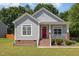 Charming home featuring a brick foundation, red front door, and a cozy front porch with white railing at 209 Mccarthy Dr, Clayton, NC 27527