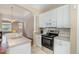 Bright kitchen featuring white cabinetry, stainless steel appliances, and a breakfast bar overlooking the living area at 209 Mccarthy Dr, Clayton, NC 27527