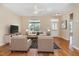 Bright living room featuring hardwood floors, large windows, a ceiling fan, and neutral wall paint at 209 Mccarthy Dr, Clayton, NC 27527
