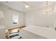 Bedroom with white bedding, hardwood floors, neutral walls, and decorative ceiling light at 2210 Bedford Ave, Raleigh, NC 27607