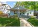Charming blue home featuring a covered front porch with rocking chairs and manicured lawn at 2210 Bedford Ave, Raleigh, NC 27607