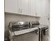 Modern laundry room features front-load washer and dryer with white cabinets above at 2210 Bedford Ave, Raleigh, NC 27607