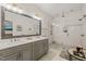 Main bathroom with double sink vanity, large mirror, and a walk-in shower with subway tile at 2210 Bedford Ave, Raleigh, NC 27607