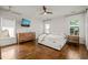 Bright main bedroom with hardwood floors, white walls, large windows, and a modern ceiling fan at 2210 Bedford Ave, Raleigh, NC 27607