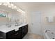 Elegant bathroom featuring dual vanity, quartz countertops, and large mirror at 232 Kanewind Ter, Apex, NC 27523