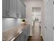 Charming butler's pantry with sleek gray cabinets, granite countertops, and decorative backsplash at 232 Kanewind Ter, Apex, NC 27523
