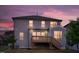Back exterior view of home, features a deck with stairs, gray siding and dusk skies at 232 Kanewind Ter, Apex, NC 27523