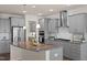 Modern kitchen boasts stainless steel appliances, granite countertops, and gray cabinetry at 232 Kanewind Ter, Apex, NC 27523