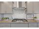 Close up of the kitchen range with stainless steel hood and granite countertop at 232 Kanewind Ter, Apex, NC 27523