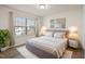 A beautifully staged main bedroom features a large window and modern furniture at 232 Kanewind Ter, Apex, NC 27523