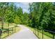 Picturesque community walking trail with scenic views and lush green landscaping and a black metal handrail at 232 Kanewind Ter, Apex, NC 27523