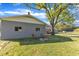 Backyard view including shade tree, stone fire pit and two wooden chairs at 2501 Ferrell Rd, Durham, NC 27704