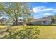Spacious backyard with a garage, back deck and mature shade tree on a sunny day at 2501 Ferrell Rd, Durham, NC 27704