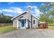 Charming home featuring a stone facade, blue front door, stone chimney, and a well-maintained gravel driveway at 2501 Ferrell Rd, Durham, NC 27704
