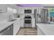 Modern kitchen with stainless steel appliances, white cabinets, and a tile backsplash, offering a sleek design at 2501 Ferrell Rd, Durham, NC 27704