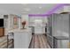 Stylish kitchen featuring a center island with seating, stainless steel appliances, white cabinets, and under-cabinet lighting at 2501 Ferrell Rd, Durham, NC 27704