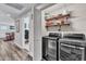 Modern laundry room with washer, dryer, storage shelves, and a folding door at 2501 Ferrell Rd, Durham, NC 27704
