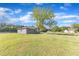 Large grassy yard with shade trees and a detached garage or accessory dwelling unit at 2501 Ferrell Rd, Durham, NC 27704