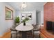 Bright dining area features a modern table, brick accent wall, and plenty of natural light at 2910 Dove Ln, Raleigh, NC 27604