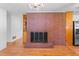 Living room featuring a brick fireplace with modern screen, hardwood floors, and built-in shelving at 2910 Dove Ln, Raleigh, NC 27604