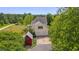 Aerial view of home featuring a two-car garage, a red outbuilding, and mature trees at 303 Crooked Meadow Ln, Hillsborough, NC 27278