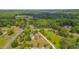 High-angle view showcasing the property's expansive surroundings with lush trees and open fields in the background at 303 Crooked Meadow Ln, Hillsborough, NC 27278